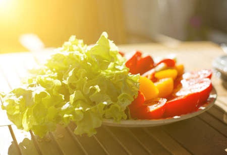 Fresh tomatoes, cucumbers and lettuce leaves on a plate.の写真素材