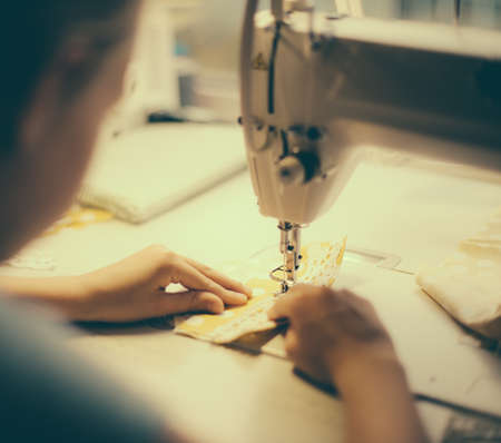 Little girl working on sewing machine at home. Close-up view.の写真素材