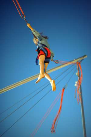 Little girl on bungee trampoline with cordsの写真素材