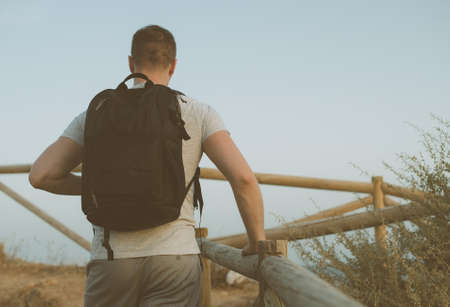 Man with backpack rises up the hill.の写真素材
