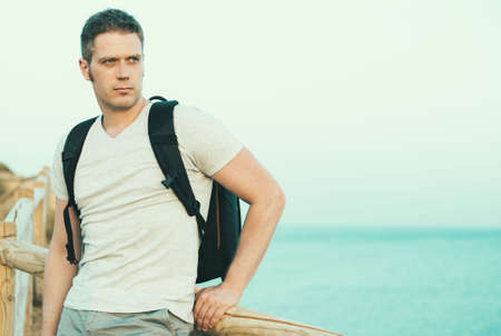 Handsome male tourist with backpack. Space for text.の写真素材