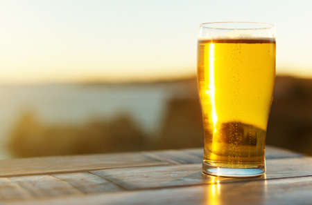 Glass of beer on the sunset.の写真素材