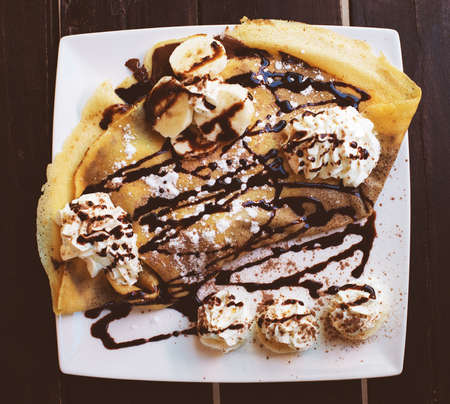 Pancakes with banana and whipped cream.の写真素材