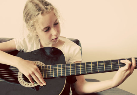 Little girl learns to play guitar.