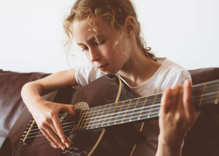 Little girl learns to play guitar.の写真素材