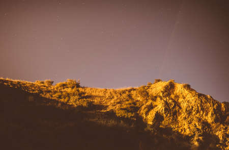 Clear night with stars above mountains.の写真素材