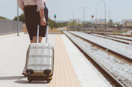 Woman with baggage is waiting for her train.の写真素材