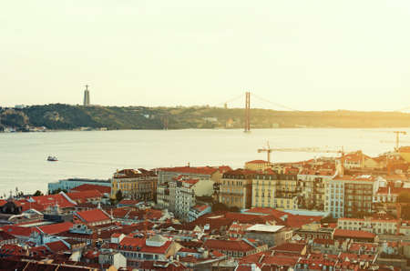 Alfama downtown and the 25 April Bridge in Lisbon at sunset.の写真素材