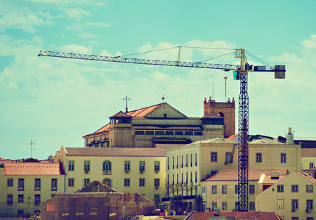 Industrial construction crane in old town.