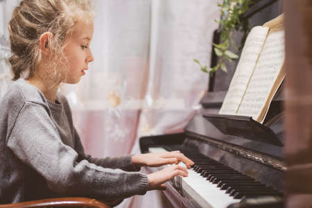 Little girl learning to play the piano.の写真素材