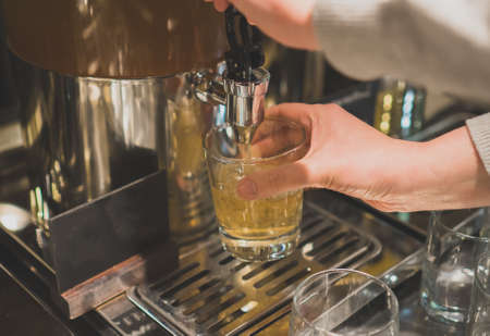 Woman pours a drink in the diner with self-service.の写真素材