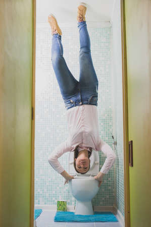 Upside down House. Woman in the toilet.の写真素材