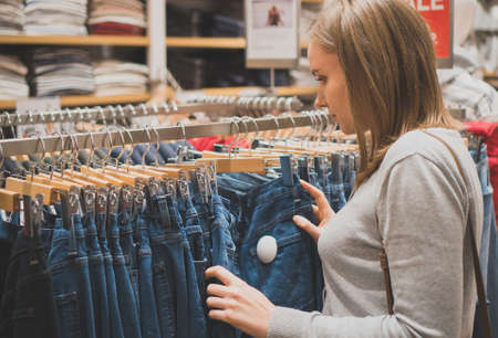 Woman choosing jeans in clothing store.の写真素材