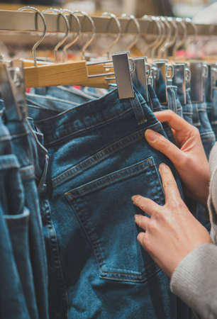 Woman choosing jeans in clothing store.の写真素材