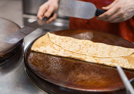 Preparation of pancake. Cook works in the kitchen.