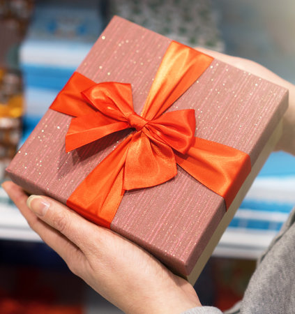 Close-up of female hands holding gift box.