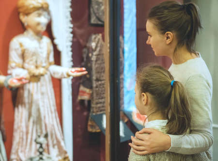 Woman and her daughter exploring expositions in museum.の写真素材