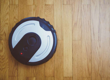 Black robotic vacuum cleaner. Space for your text.の写真素材