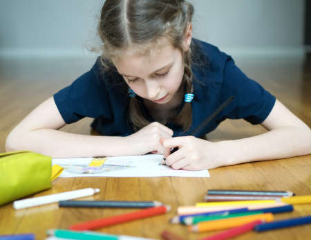 Little girl drawing with pencil at home.の写真素材