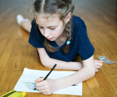 Little girl drawing with pencil at home.の写真素材