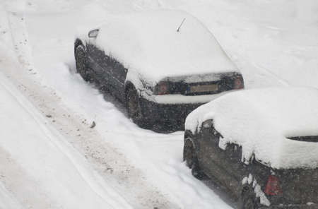 Cars covered with snow on the street in winter.の写真素材