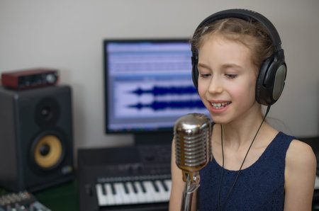 Little girl singing a song in home recording studio.