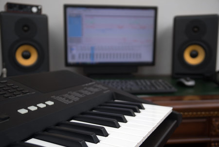 Home recording studio with professional monitors and midi keyboard.