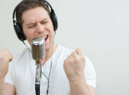 Handsome man recording a song. Space for your text.の写真素材