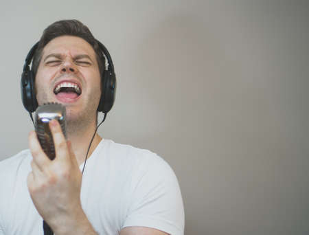 Handsome man recording a song. Space for your text.の写真素材