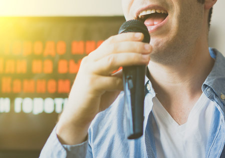 Man singing karaoke at home. Close-up view.