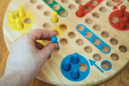 Man playing Ludo board game. Close-up view.の写真素材