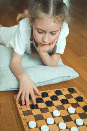 Little cute girl playing checkers board game.の写真素材