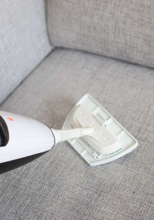 Cleaning fabric of the sofa with a steam cleaner.の写真素材