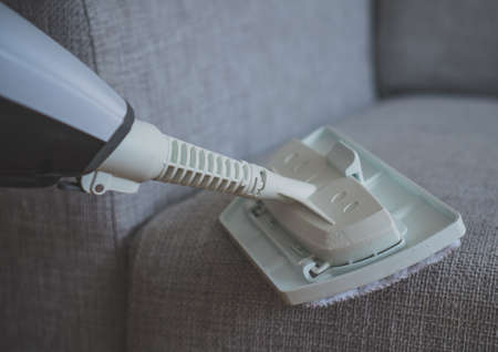 Cleaning fabric of the sofa with a steam cleaner.の写真素材