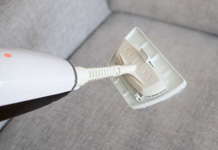 Cleaning fabric of the sofa with a steam cleaner.の写真素材