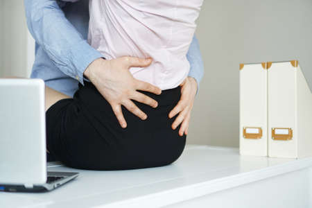 Sexual flirt at work. Man touching woman's butt.の写真素材