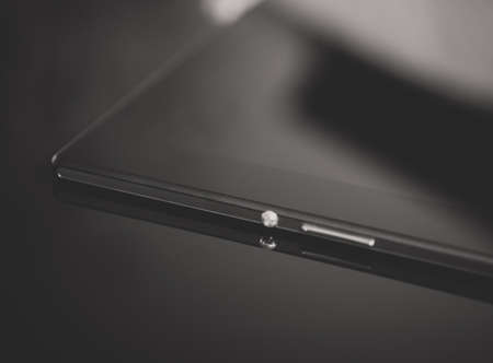 Black tablet pc on mirrored surface. Space for your text.の写真素材