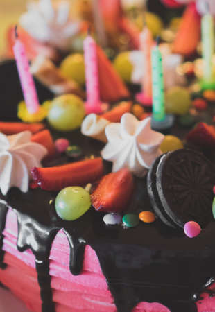 Pink chocolate cake with strawberries, meringues and grapes.の写真素材