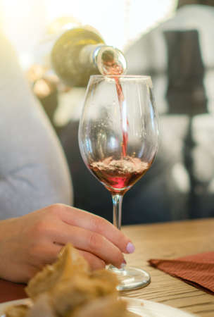 Pouring red wine from bottle into glass. Wine degustation.の写真素材