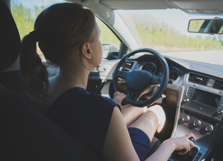 Woman is driving a car. Inside view.