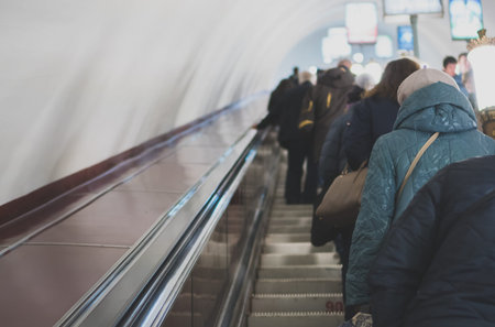 People riding the escalator in metro station.
