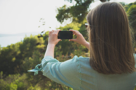 Woman takes pictures of nature by mobile phone.
