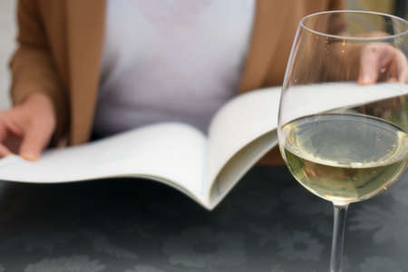 Woman with menu choosing dishes at restaurant.の写真素材
