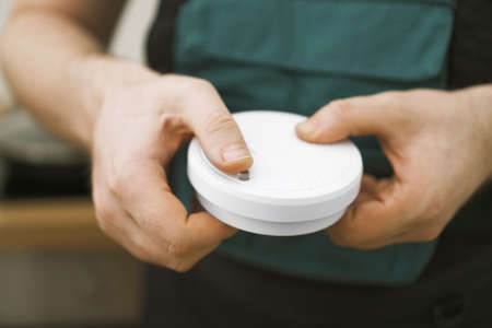 Man testing smoke detector before use.の写真素材
