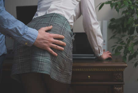 Sexual harassment at work. Man touching woman's buttの写真素材