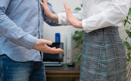 Sexual harassment at work. Boss touching his secretary in office.の写真素材