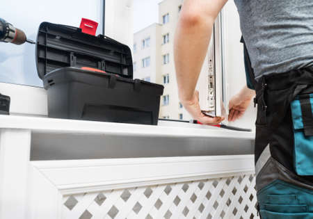 Professional handyman installing window at home.の写真素材