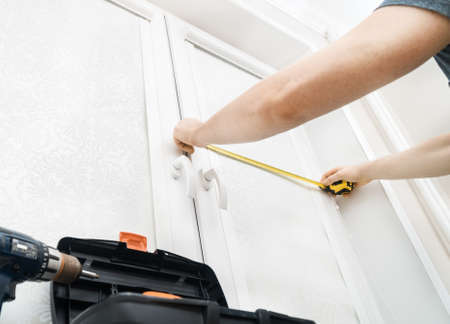 Man installing cassette roller blinds on windowsの写真素材