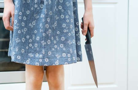 Dangerous situation in the kitchen. Child with kitchen knife in hand.の写真素材