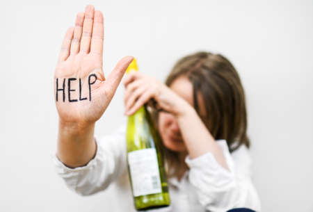 Alcoholism concept. Woman with bottle of wine.の写真素材